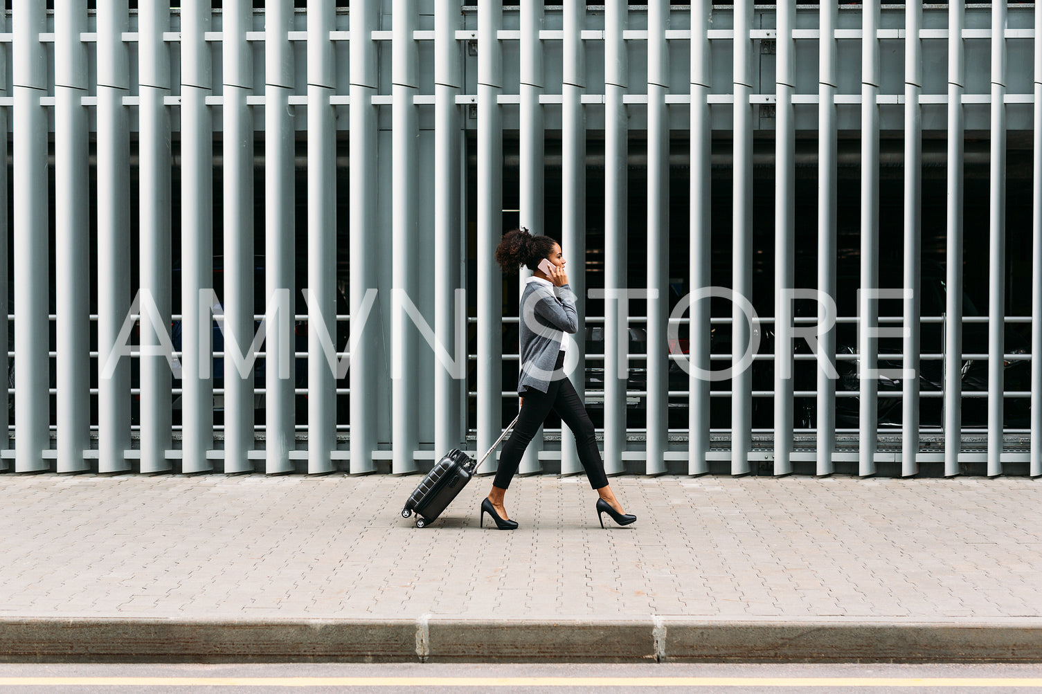 Side view of young businesswoman walking with suitcase	