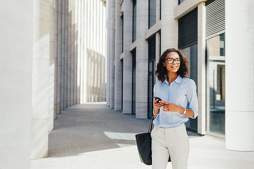 Businesswoman wearing formal clothes standing in front of a modern office building