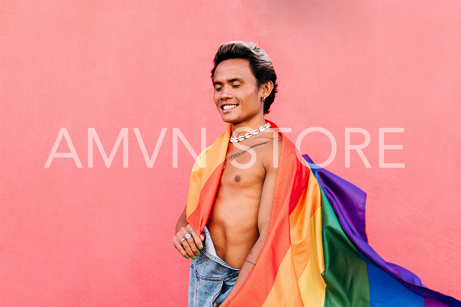 Happy guy with closed eyes holding a rainbow LGBT flag while sta