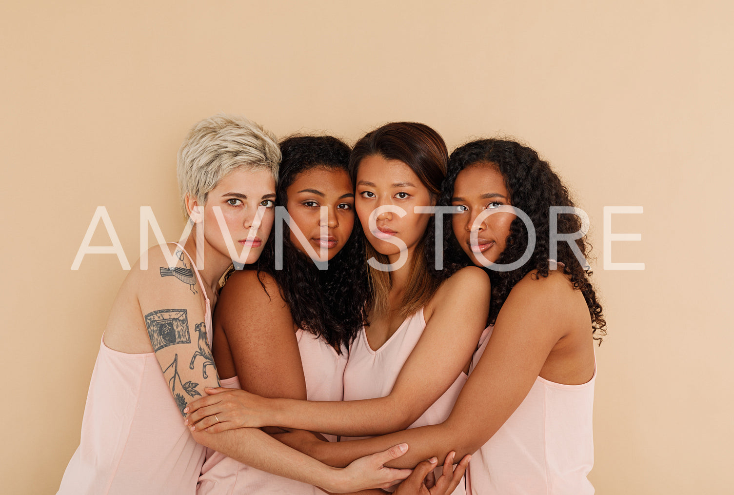 Four different women embracing each other. Young females posing together.