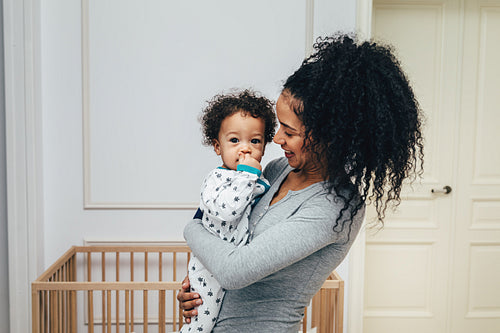 Smiling mother holding her child in living room