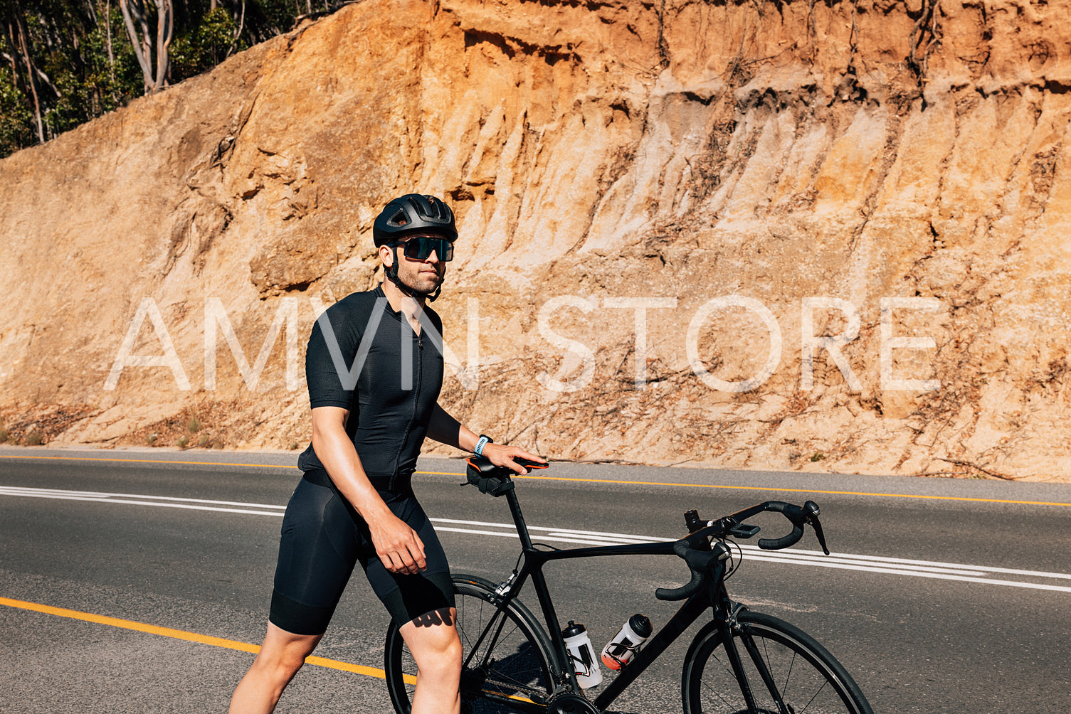 Professional cyclist walking with his road bike on a roadside