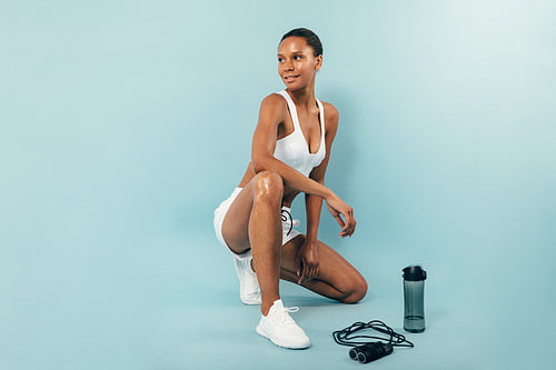 Smiling woman resting after training in studio looking away