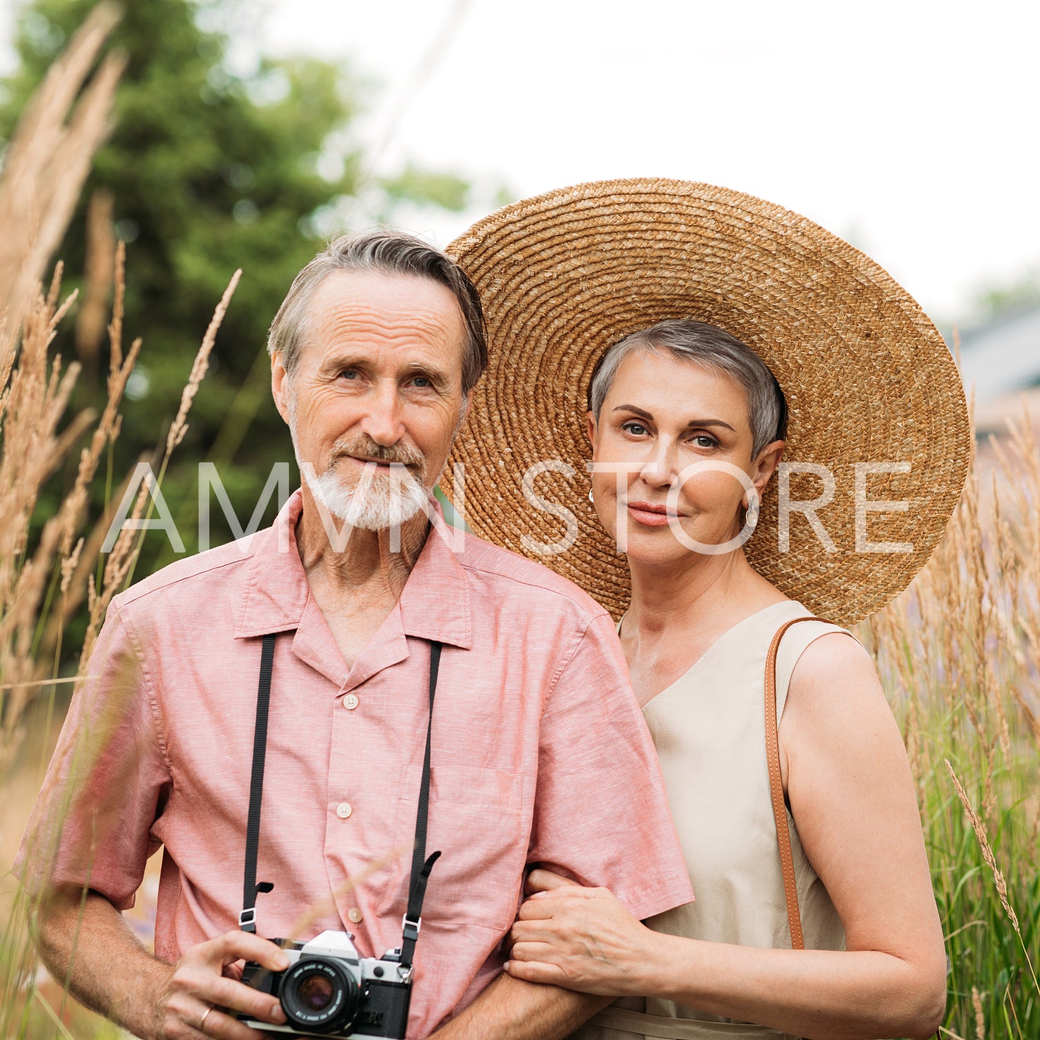 Portrait of two aged tourists standing on a wheat field