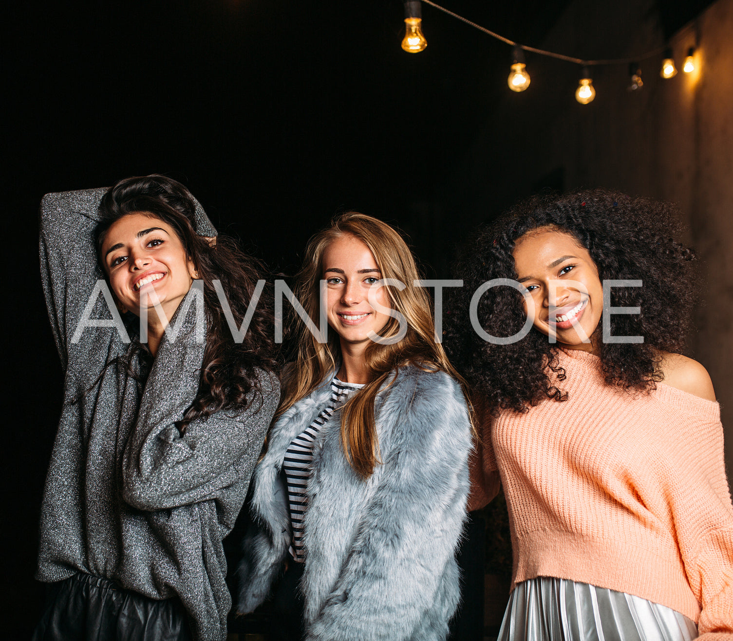 Portrait of three young stylish women at night