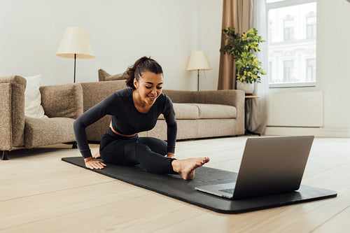 Mixed race woman repeating exercises from fitness instructor online