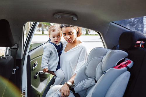 Young parent adjusting baby seat before putting daughter into it