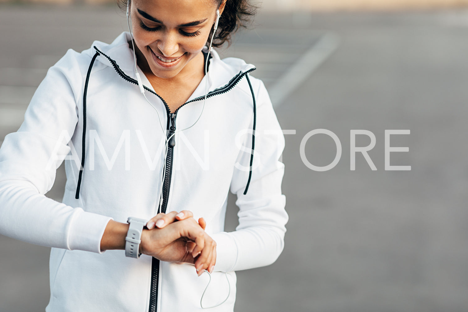 Young woman listening to music with earphones and checking her activity on a smartwatch during training.	