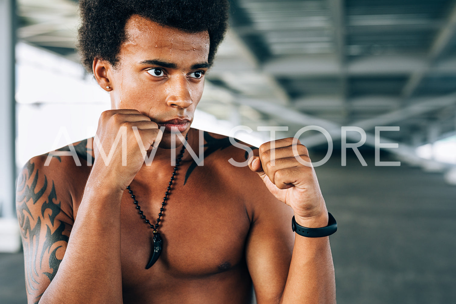 Close up of a male kickboxer doing shadow boxing. Bare chested man practicing his moves outdoors.	