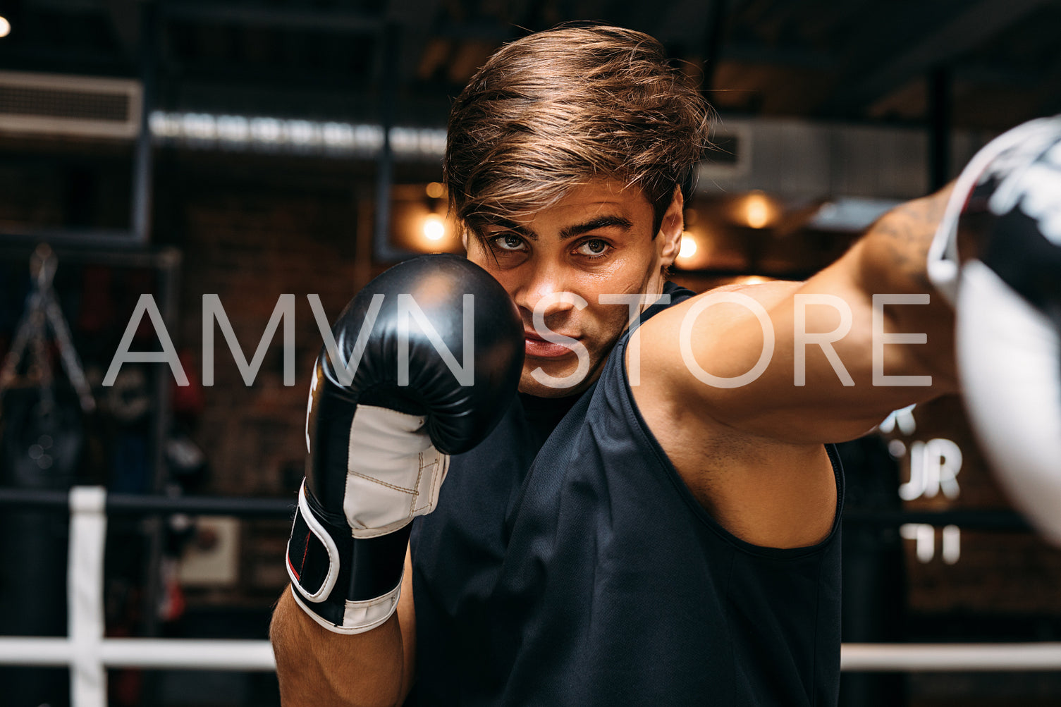 Close up of a male sportsman doing shadow boxing inside a boxing ring	