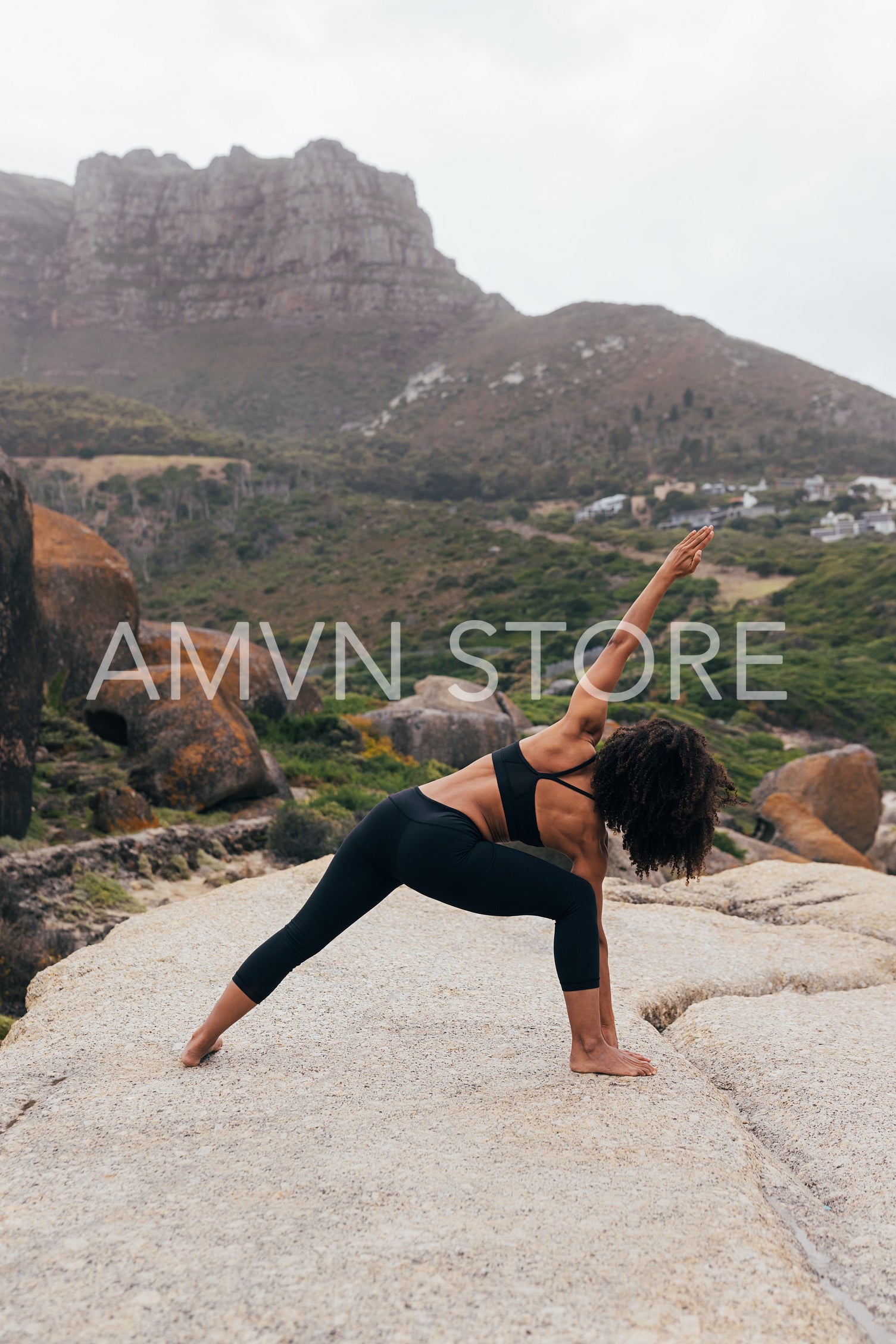 Back view of slim female practicing Utthita Parsvakonasana against valley with mountains