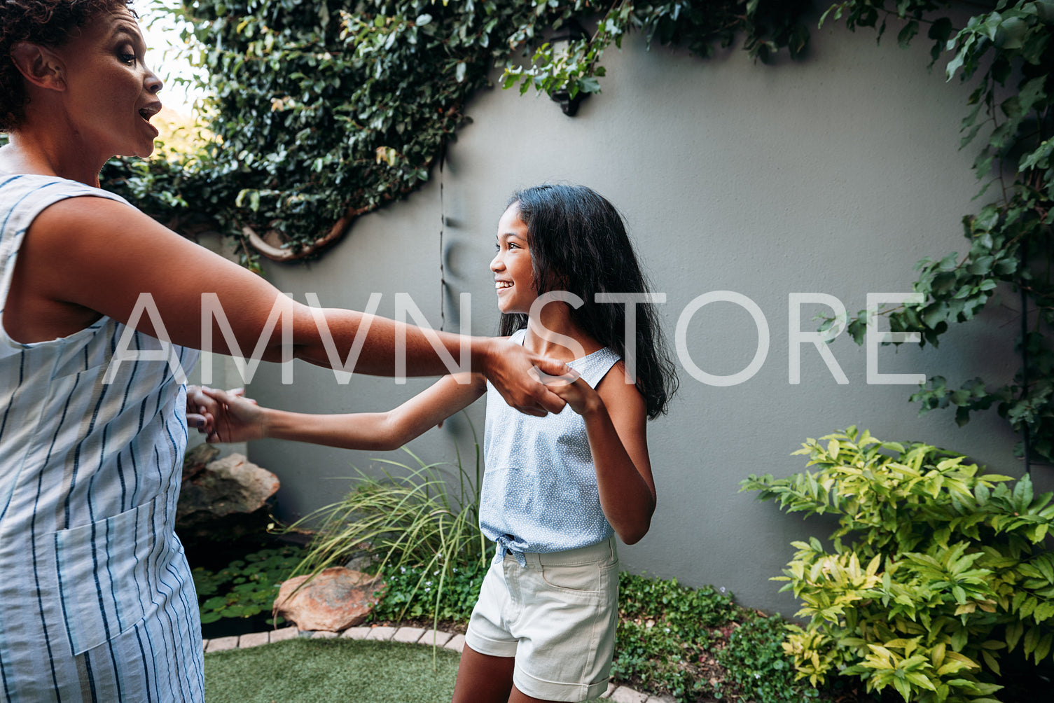 Mature woman with her granddaughter holding hands enjoying time together outdoors