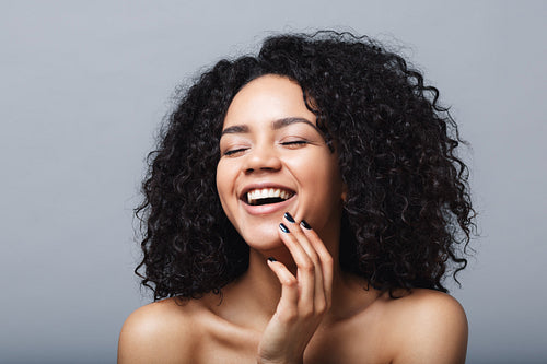 Happy brunette woman posing against gray background