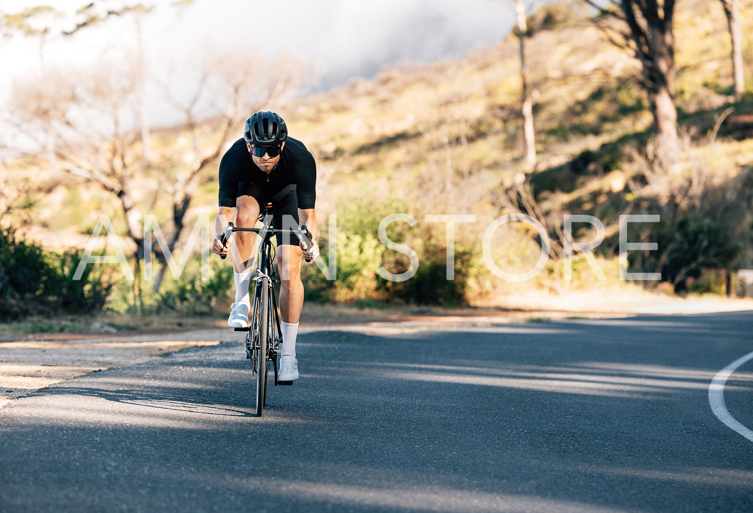 Professional cyclist on his road bike. Male cyclist exercising on an empty road.