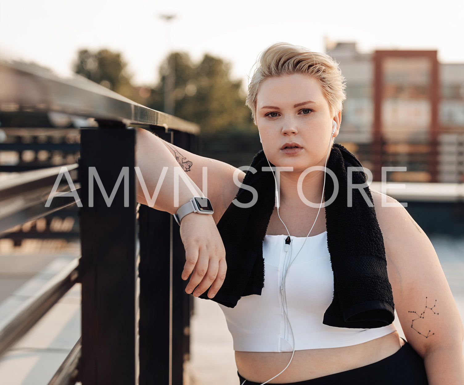 Portrait of a curvy caucasian woman leaning on a railing relaxing after a workout