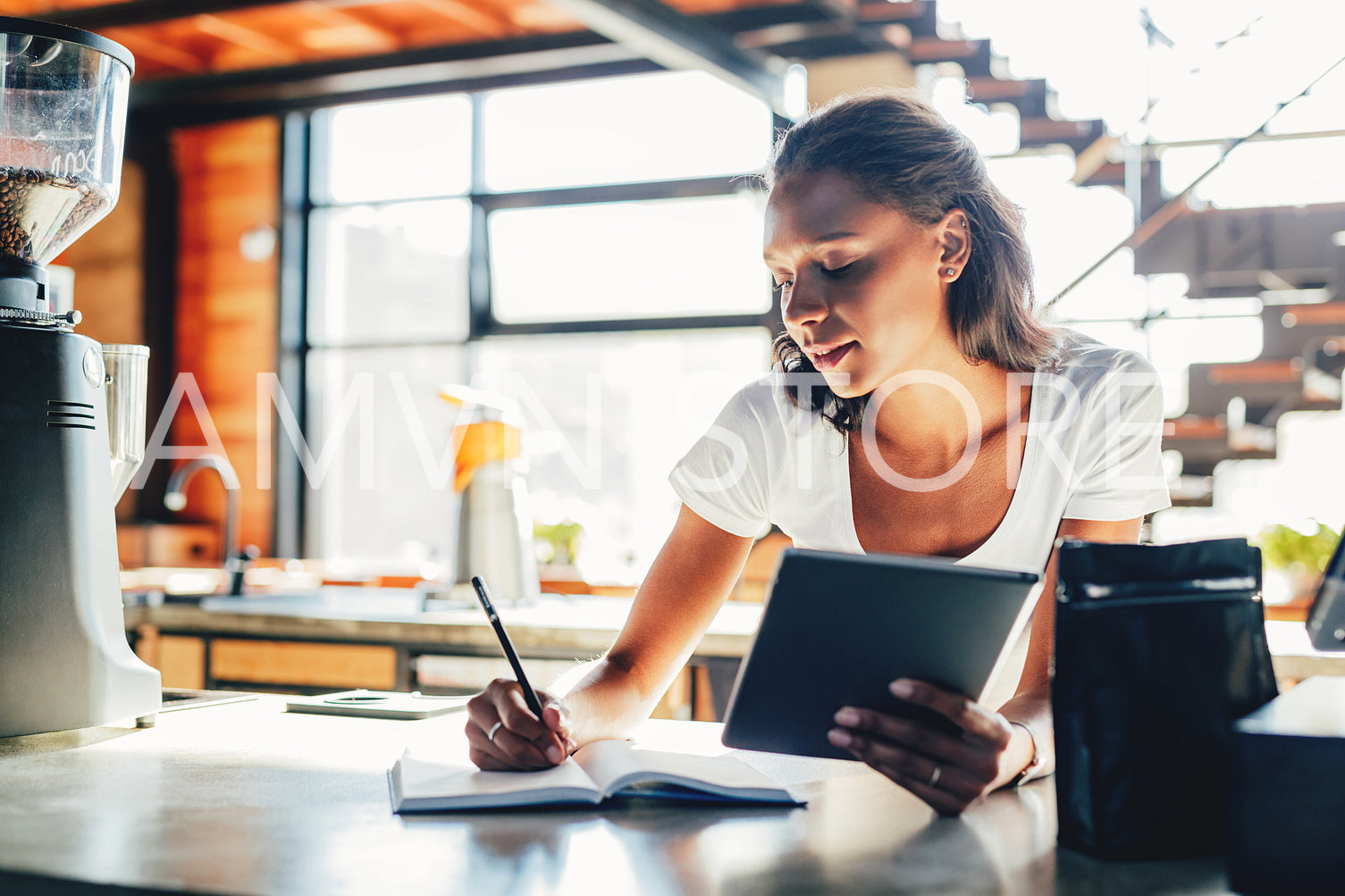 Woman standing by a counter while reviewing business files	