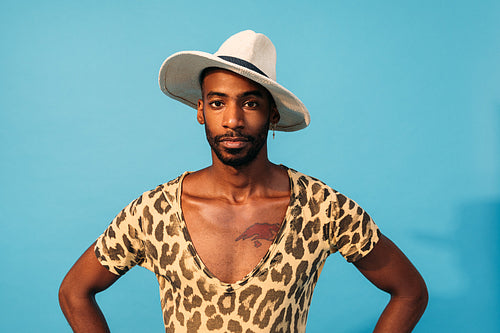 Stylish guy posing in studio against blue background looking at camera