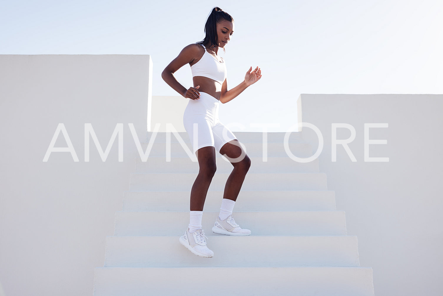 Full length of a young female practicing outdoors. Slim sportswoman jogging on stairs warming up before a workout.outdoors.