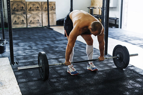 Young athlete preparing for deadlifting in gym