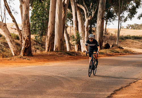 Female athlete riding a pro bike on countryside road