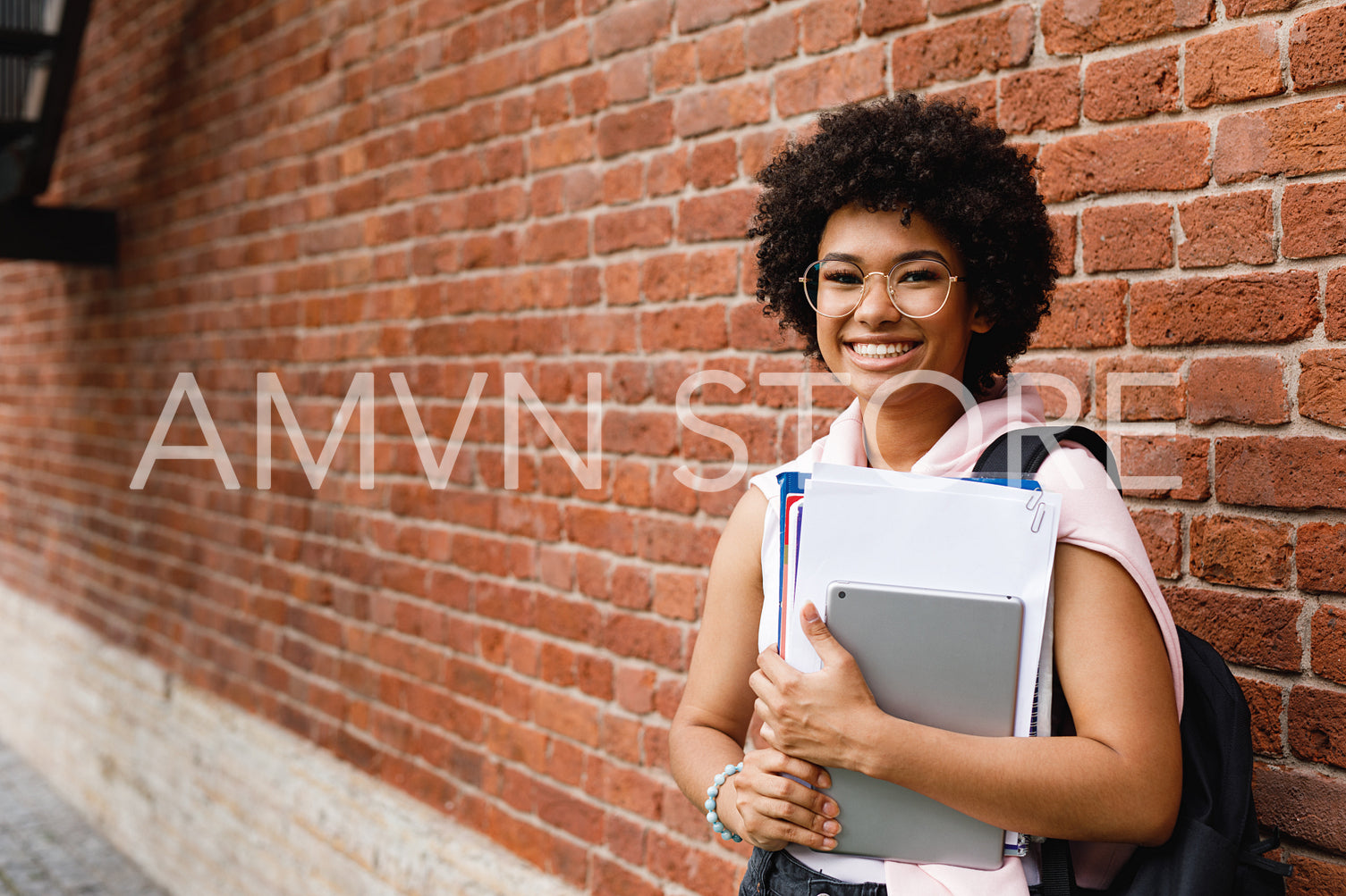 Young female student with books and digital tablet at campus	