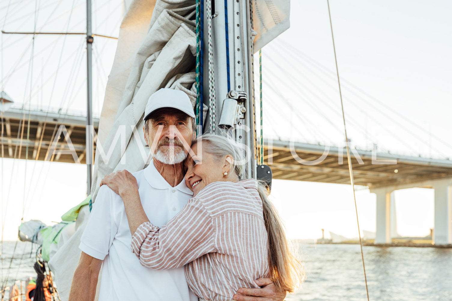 Portrait of affectionate mature couple embracing each other while standing on a sailboat. Senior couple enjoying their vacation.	