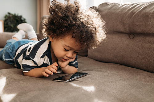 Toddler watching video on a smartphone at home