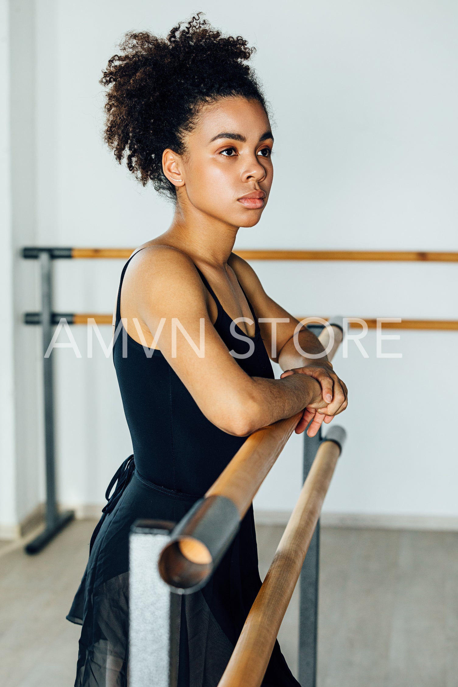 Portrait of African American ballet dancer standing at barre in studio	