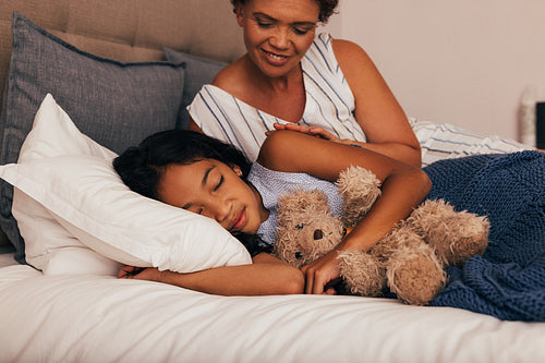 Granny looking at her granddaughter while she sleeping