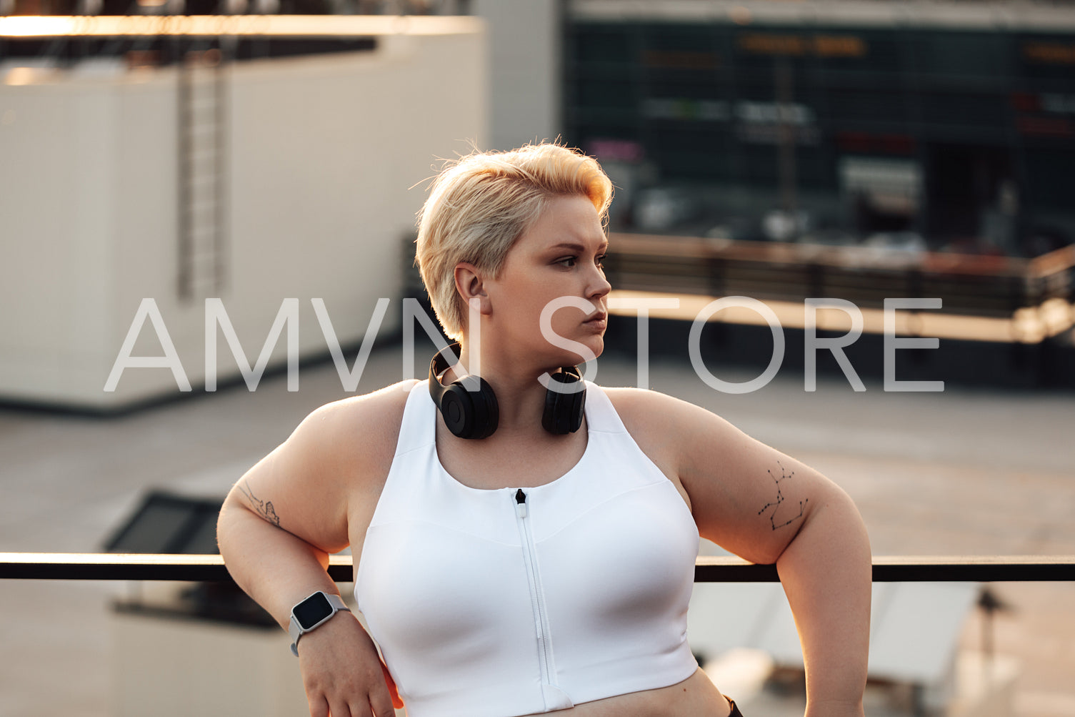 Side view of curvy woman with short hair leaning on a railing looking away