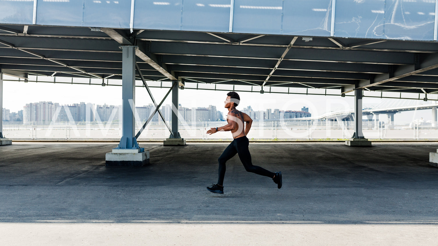 Side view of athletic bare chested man jogging outdoors on sidewalk	