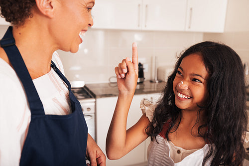 Smiling girl trying to make marks on granny's face using flour