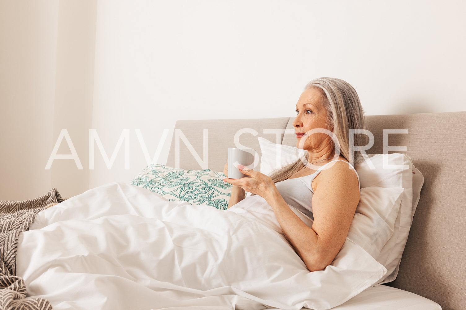 Senior woman with a cup. Aged female in the morning in bedroom.