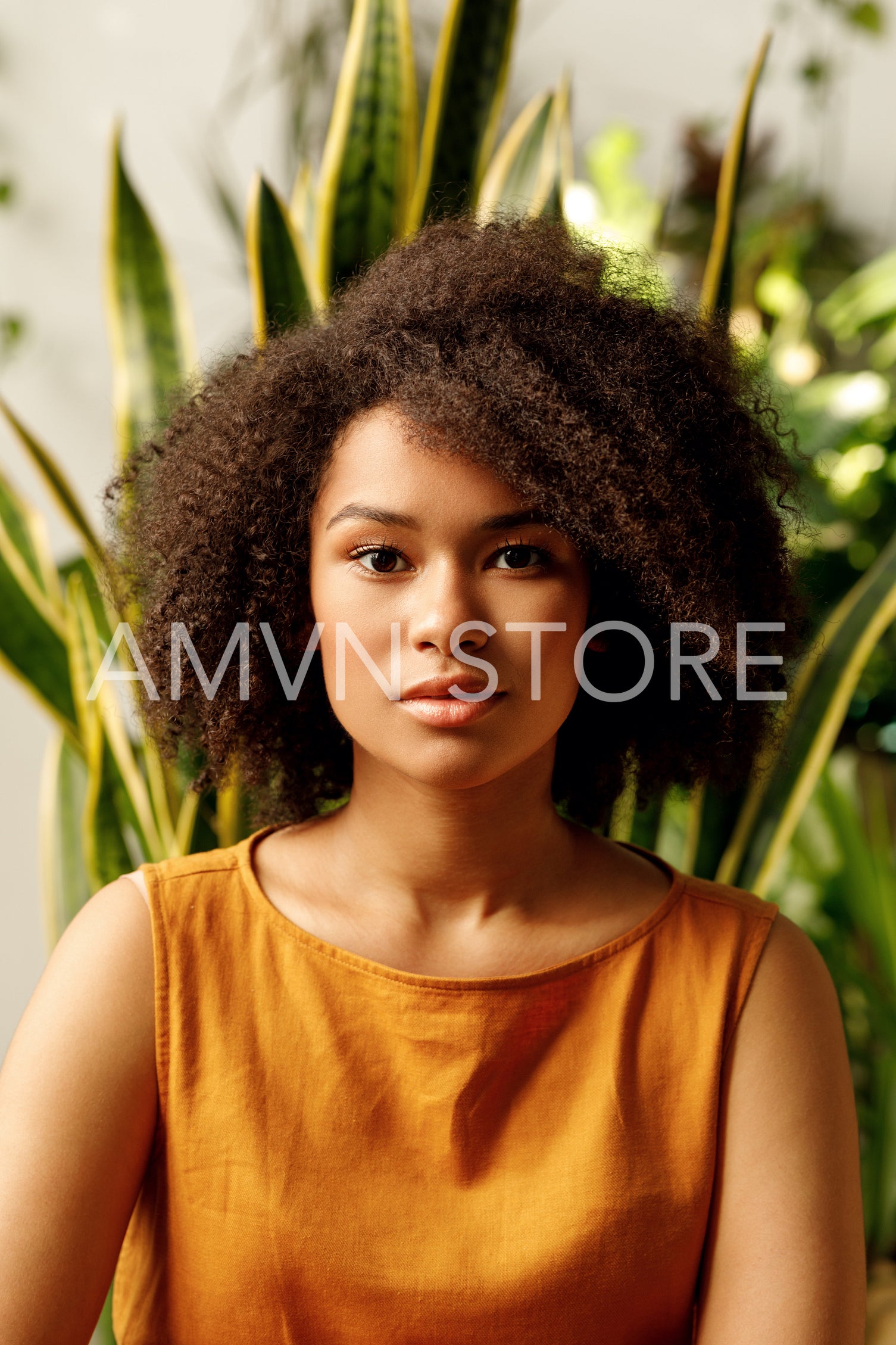 Portrait of a beautiful young woman looking at camera in plant shop	