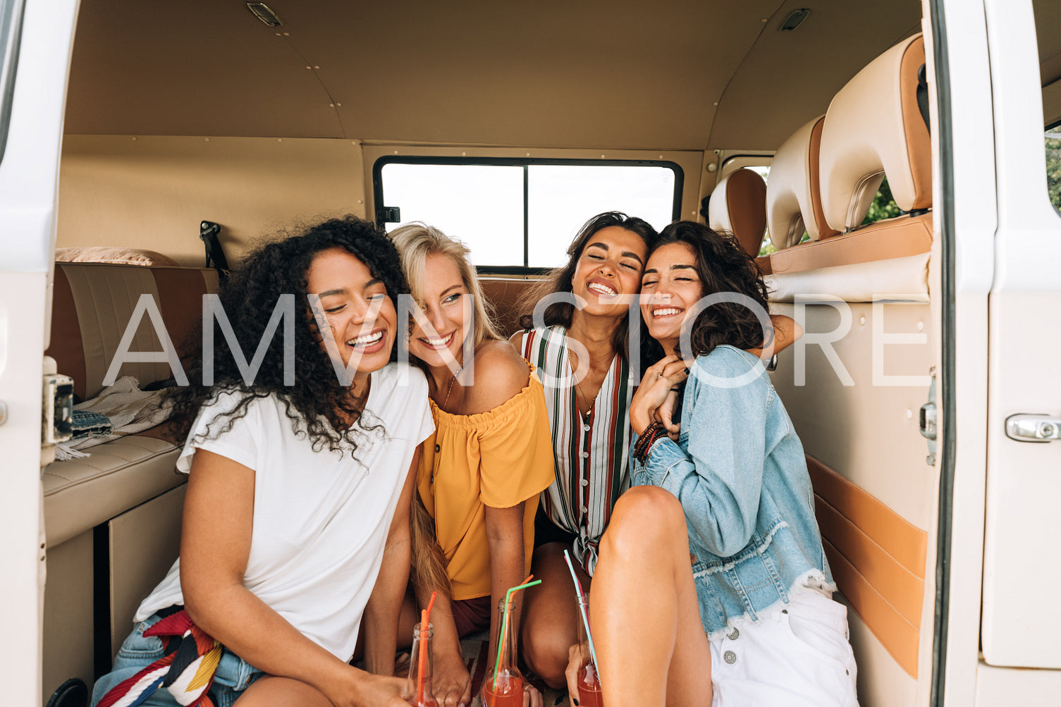 Happy young women sitting together in camper van enjoying vacation