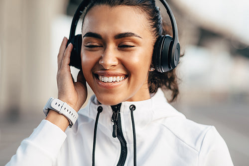 Happy woman enjoying music with closed eyes during training