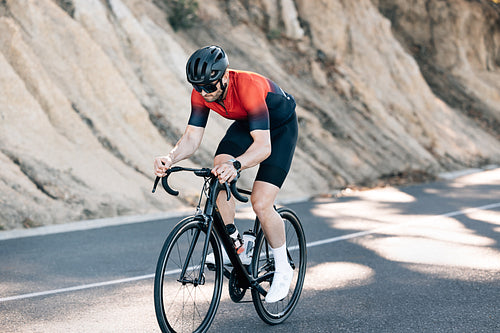 Professional male cyclist riding his bicycle outdoors