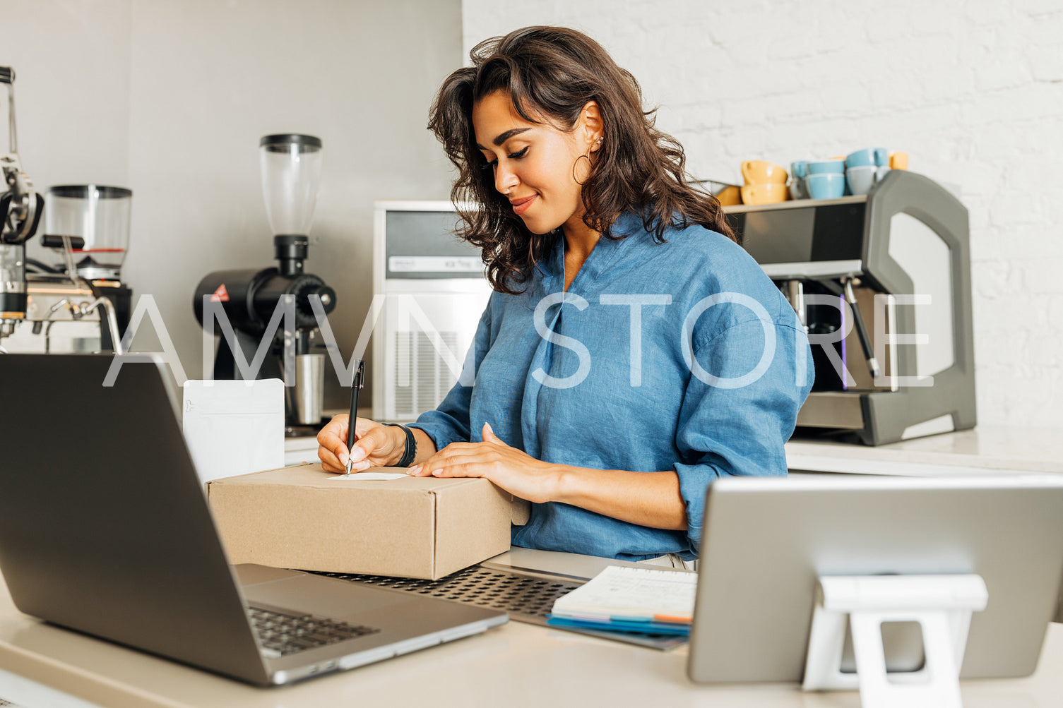 Smiling entrepreneur woman finishes preparing the parcel for shipment	