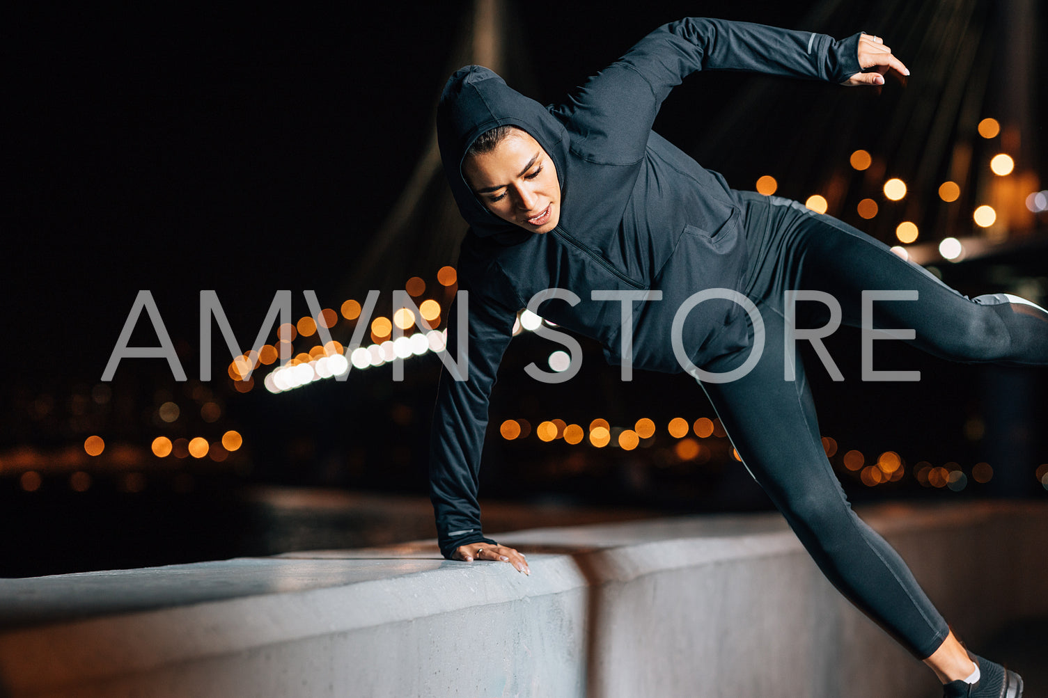 Female in hooded sport shirt exercising outdoors 