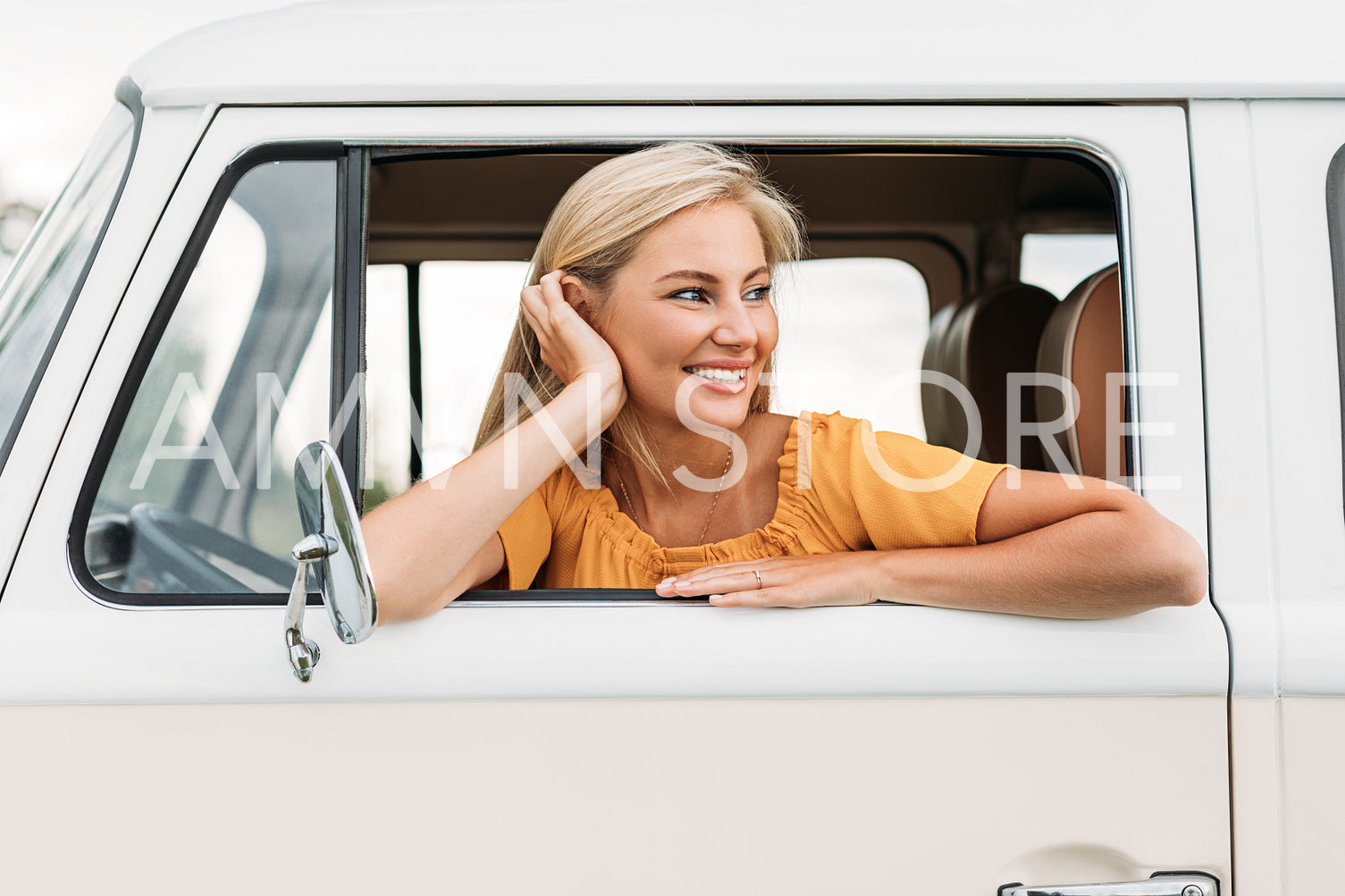 Beautiful young woman looking out of the car enjoying a great time while traveling 