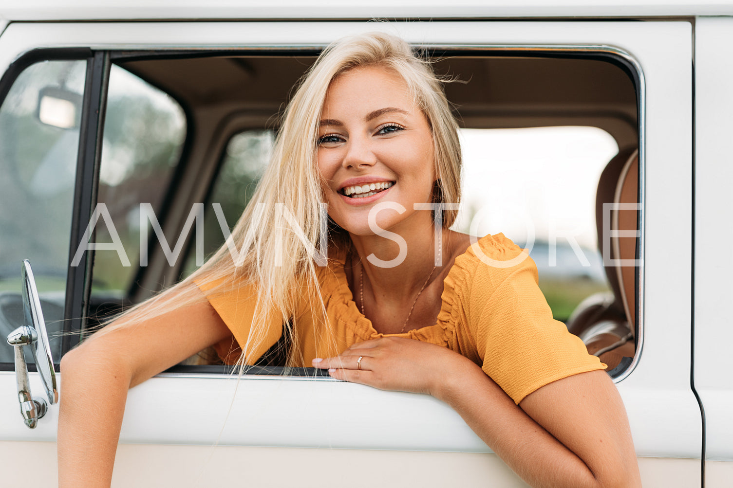 Happy female looking out of a window of van enjoying summer vacation 