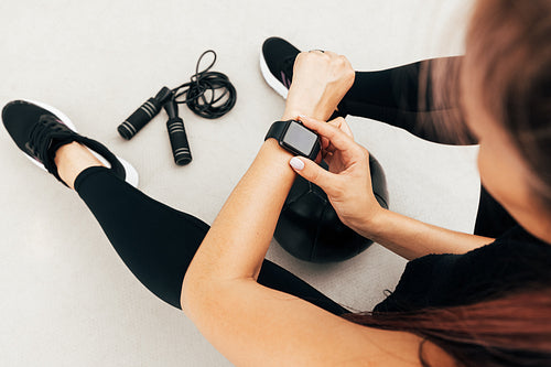 Cropped shot of unrecognizable sportswoman looking at smartwatch outdoors