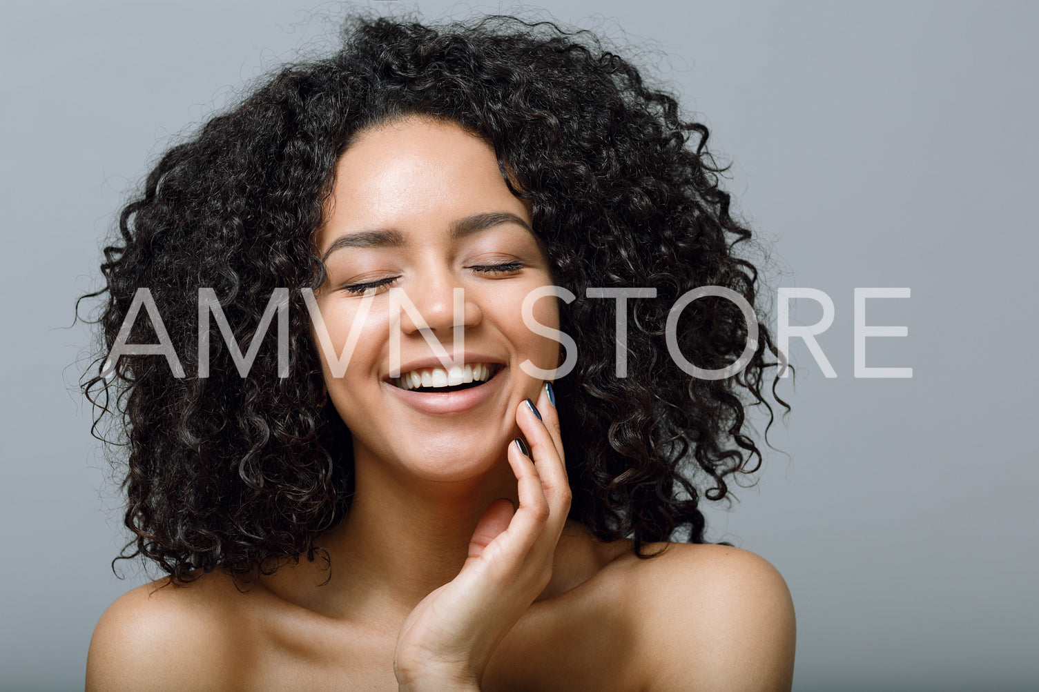 Portrait of a woman with curly hair and closed eyes, studio shot	