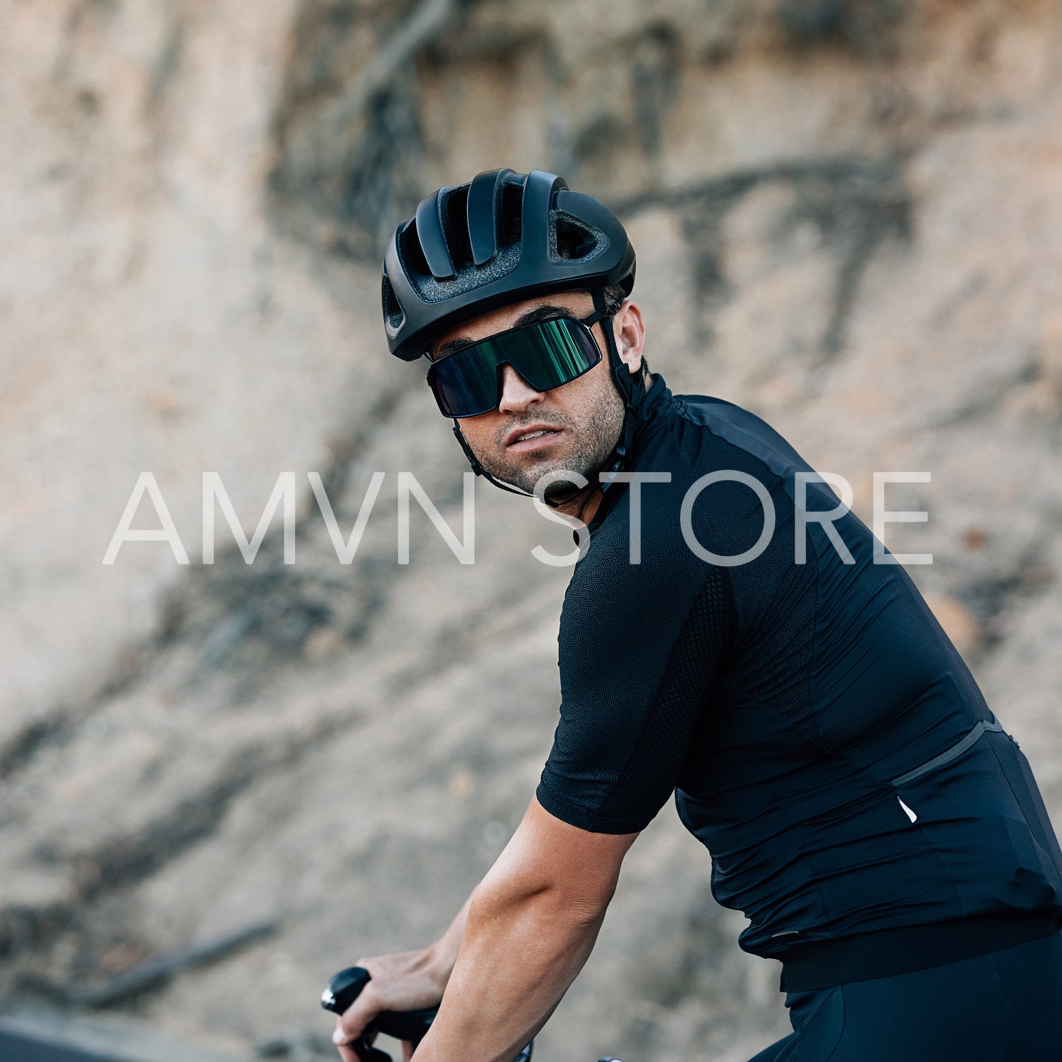 Portrait of a male cyclist in helmet and glasses outdoors looking at the camera