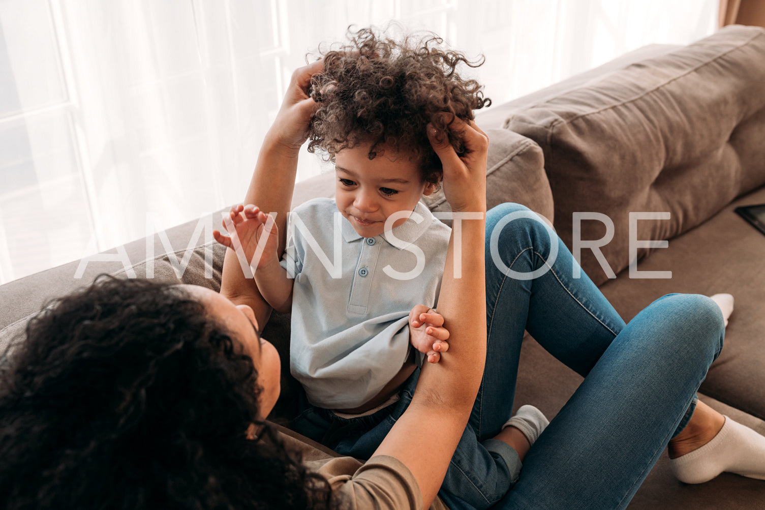 Curly little boy and his mother spending time together at home during a lockdown	