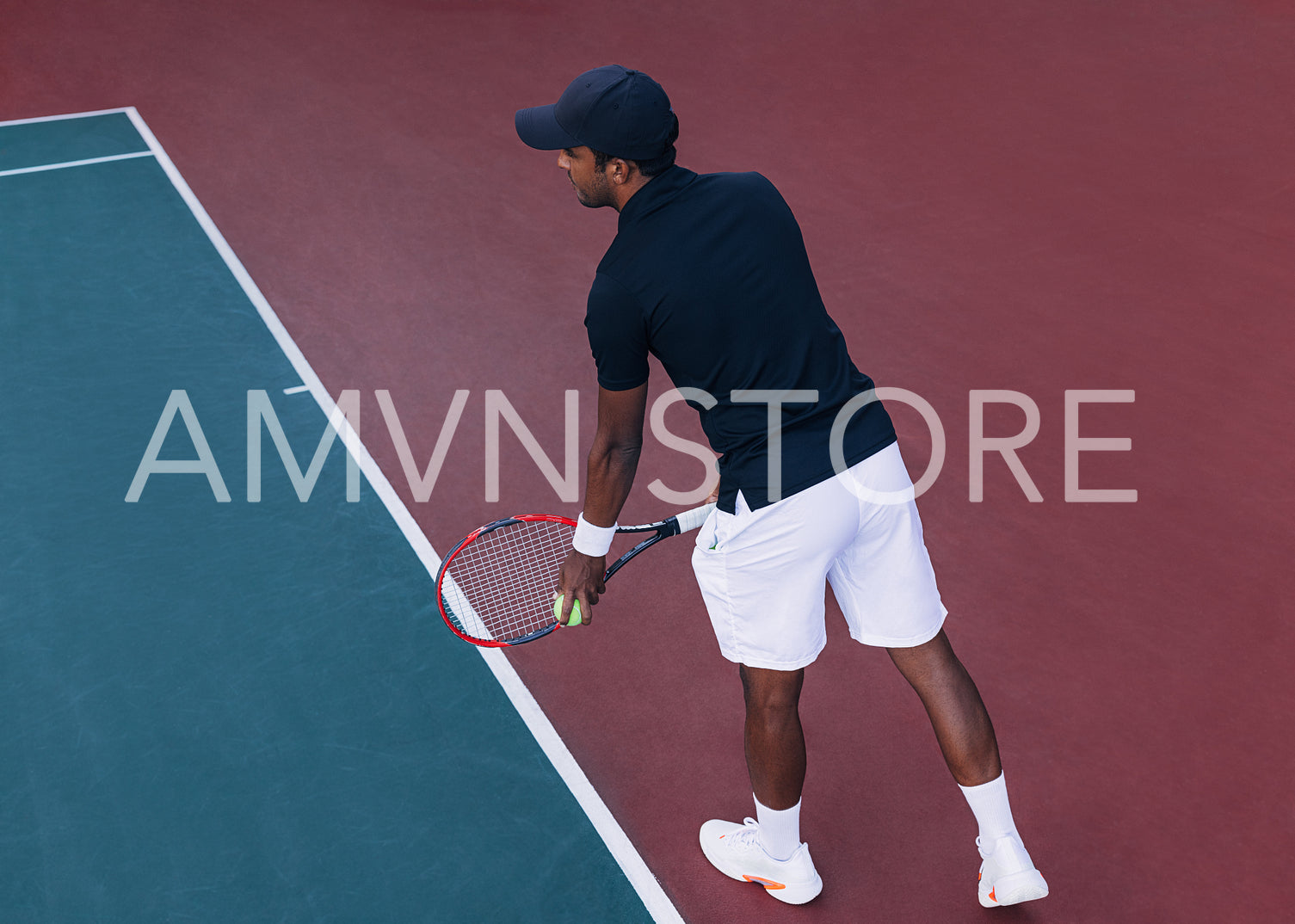 Male tennis player at baseline preparing to serve on hard court