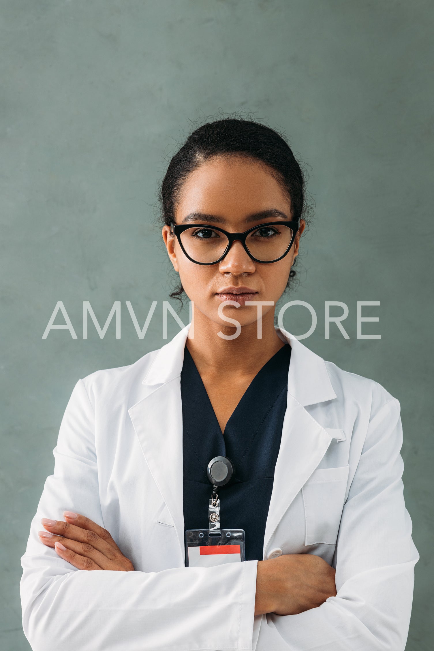 Portrait of a serious medical worker standing with crossed arms and looking at camera	