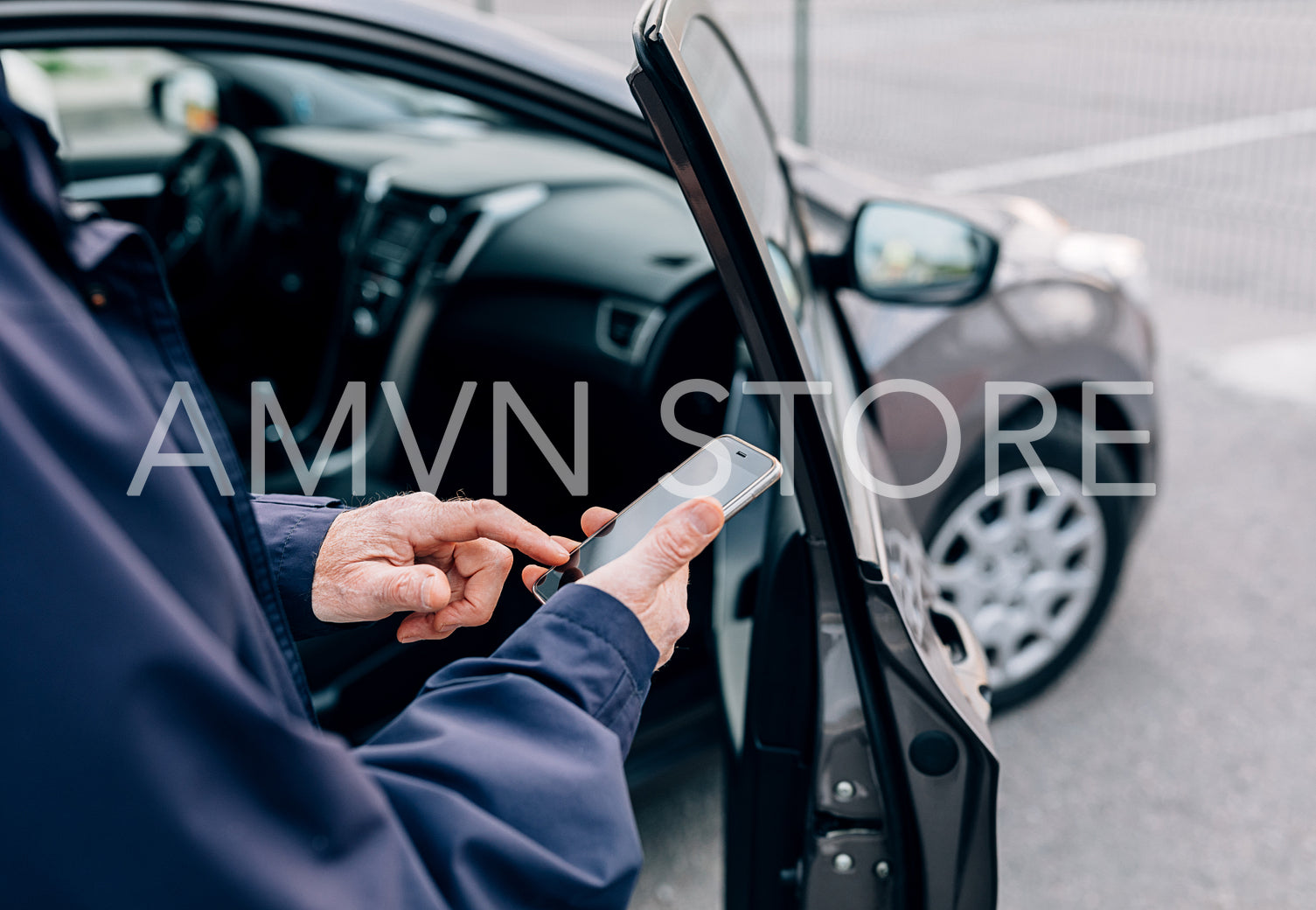 Male hands typing on cell phone. Unrecognizable mature man standing at rental car with smartphone.	