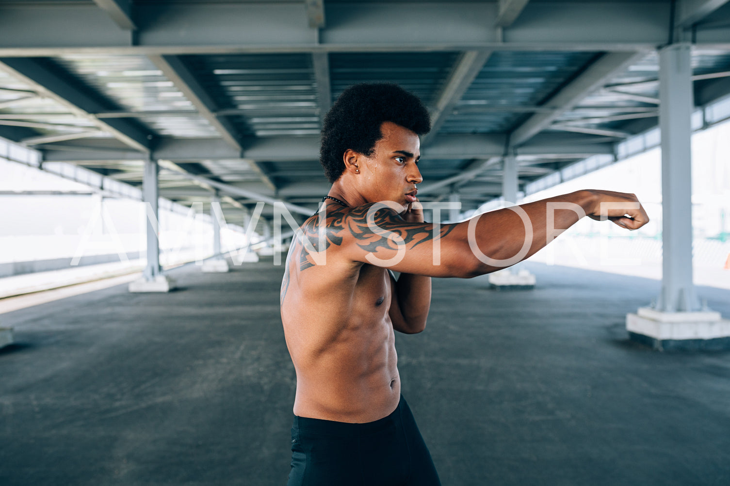 Side view of young kickboxer practicing his punches	