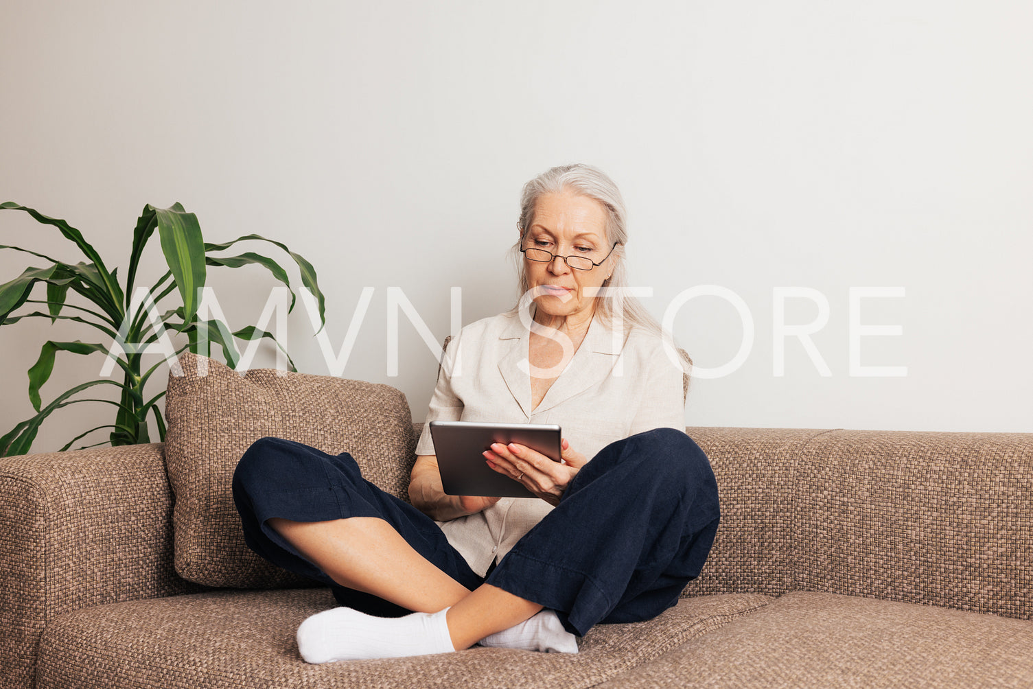 Woman in eyeglasses sitting on a sofa